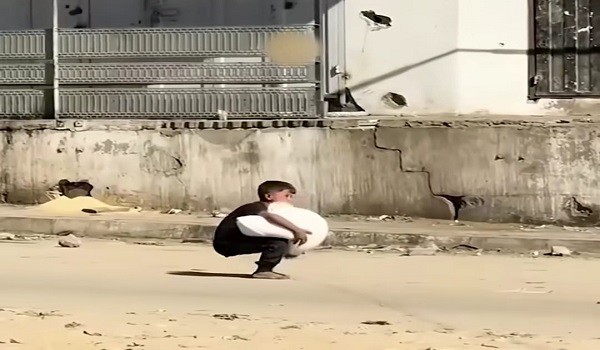 طفل فلسطيني يحمل كيس طحين