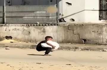 طفل فلسطيني يحمل كيس طحين