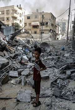 صبي من غزة ينظر إلى الدمار الذي سببه القصف في أحد أحياء القطاع
