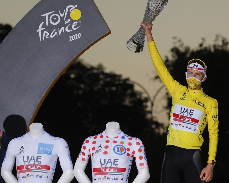Tour de France winner Slovenia's Tadej Pogacar, wearing the overall leader's yellow jersey, celebrates on the podium after the twenty-first and last stage of the Tour de France cycling race over 122 kilometers (75.8 miles)