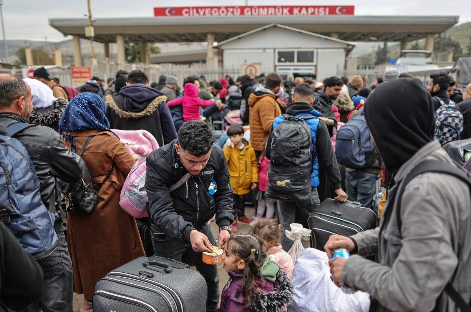 سوريين أمام بوابة الحدود التركية يستعدون للعودة لبلادهم