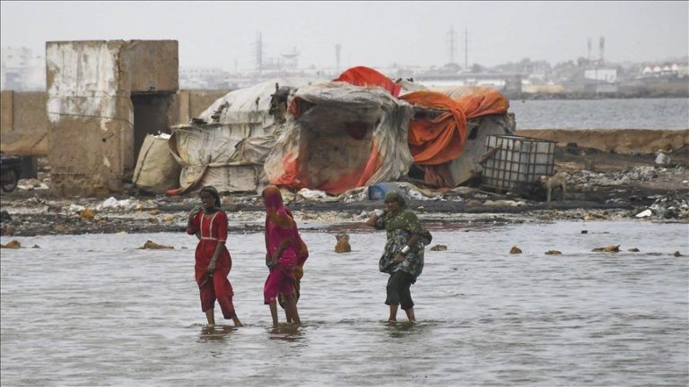 Pakistani flood victims cross sea water