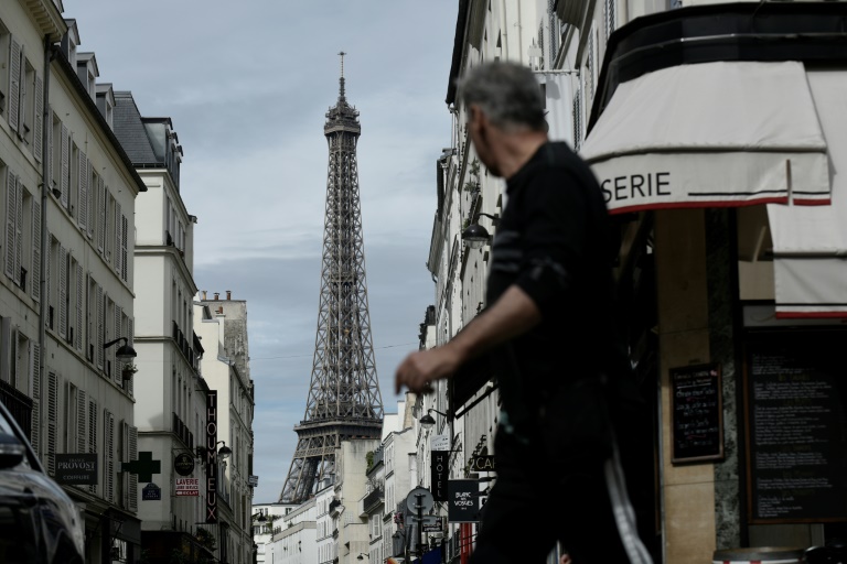 رجل يسير في شارع قرب برج ايفل في باريس  