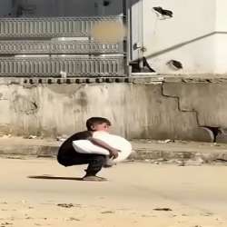 طفل فلسطيني يحمل كيس طحين