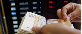 أحد العاملين يعد أوراق نقد فئة 100 درهم بمكتب للصرافة في الدار البيضاء 