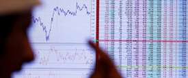 مستثمر ينظر الى شاشة تعرض معلومات عن الأسهم في الرياض