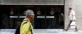 رجلان يسيران امام مقر البنك المركزي الفنزويلي في كراكاس 
