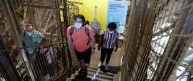 People wearing protective face masks climb the stairs as they visit the Eiffel Tower in Paris on its reopening day to the public following the coronavirus disease (COVID-19) outbreak 