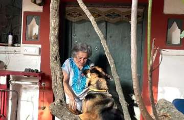 Almrita Patel plays with her dog outside her farmhouse
