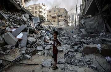 صبي من غزة ينظر إلى الدمار الذي سببه القصف في أحد أحياء القطاع